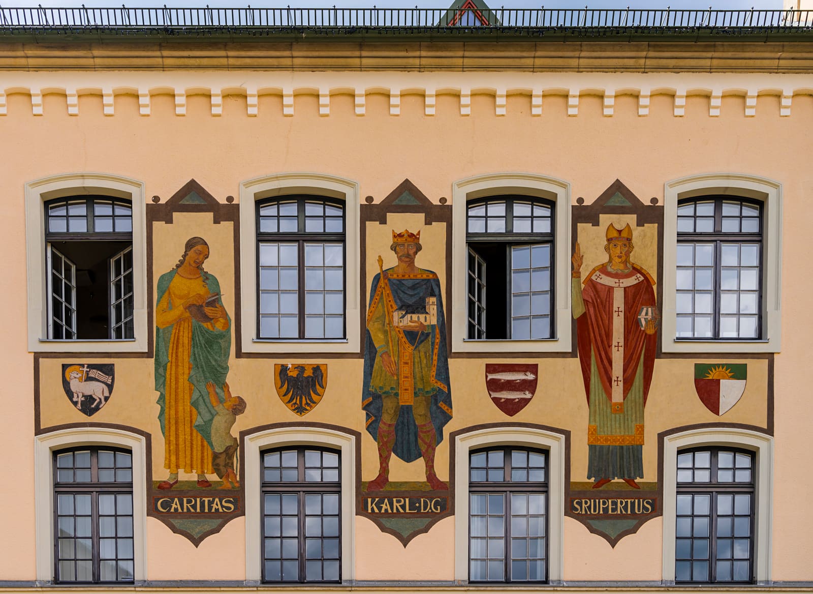 Historische bemalte Fassade in Bad Reichenhall mit Caritas, Karl dem Großen, Rupertus und mehreren Stadtwappen