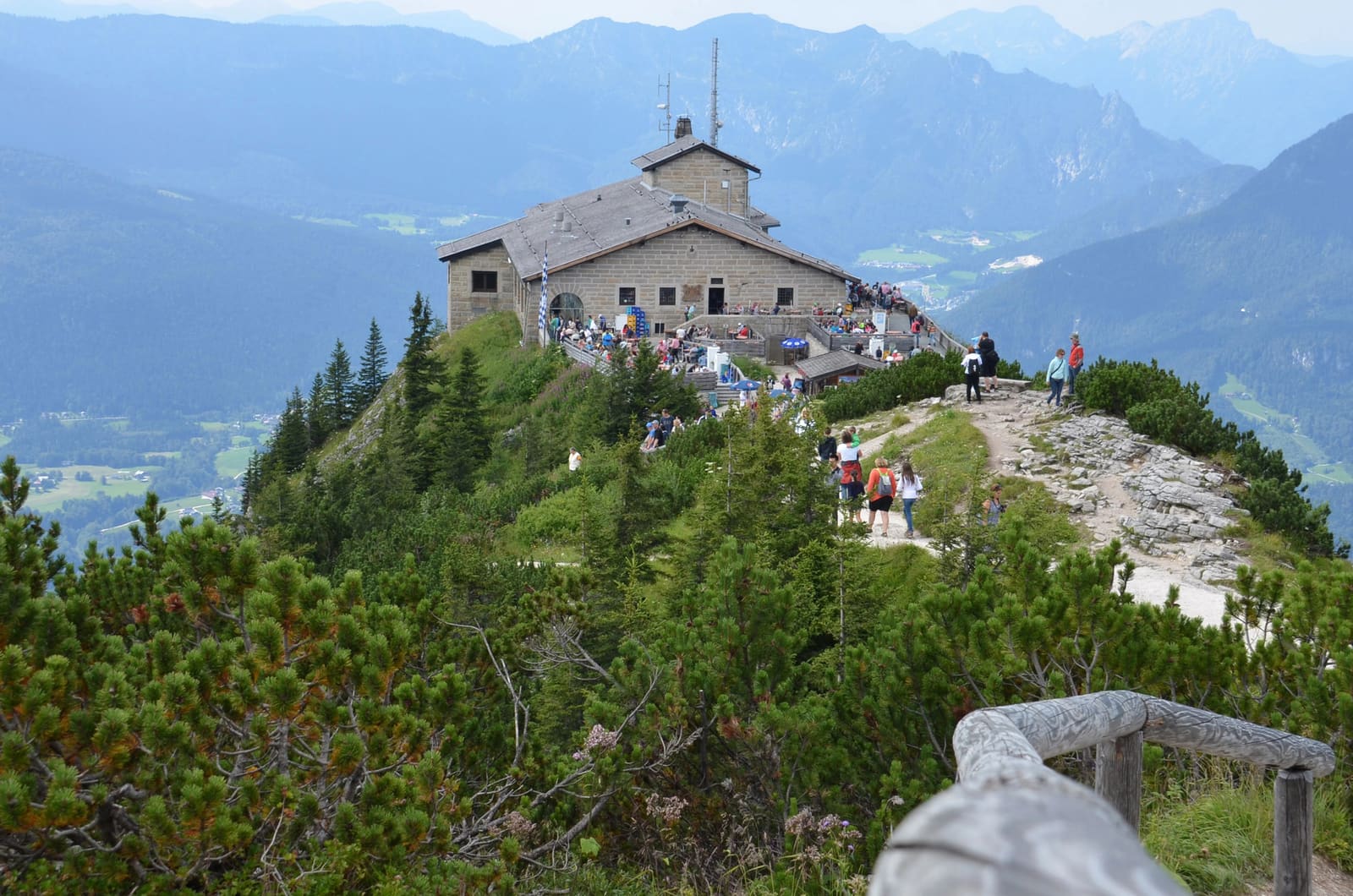 Kehlsteinhaus auf einem felsigen Bergrücken über Berchtesgaden mit Besuchern und weitem Alpenpanorama