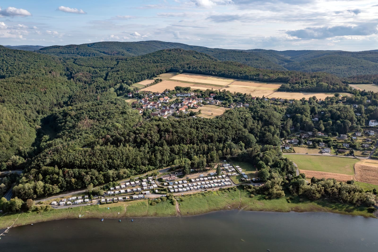 Luftbild vom Ederseeufer bei Bringhausen mit Campingplatz, Dorf, Feldern und dicht bewaldeten Höhen des Kellerwalds