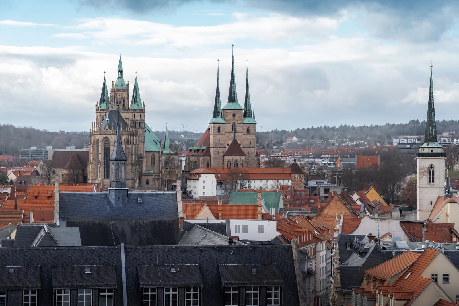 Panoramablick über Erfurts rote Altstadtdächer zum Mariendom und zur Severikirche unter wechselhaftem Himmel