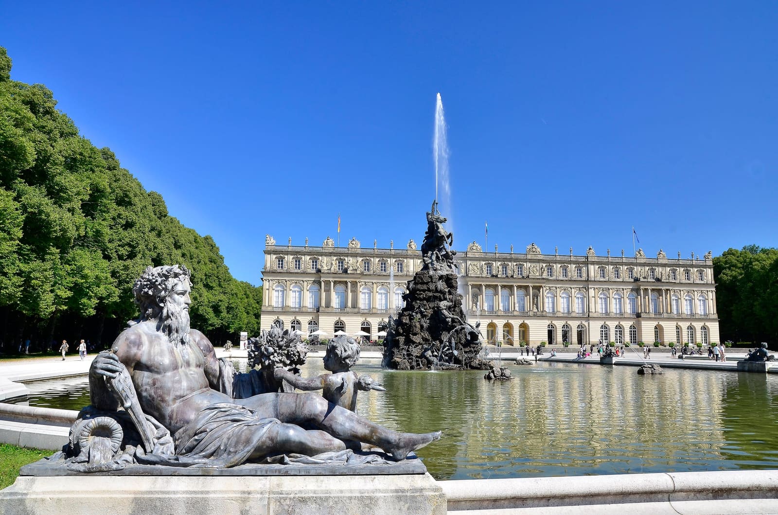 Die Westfassade von Schloss Herrenchiemsee mit Gartenparterre und Brunnen