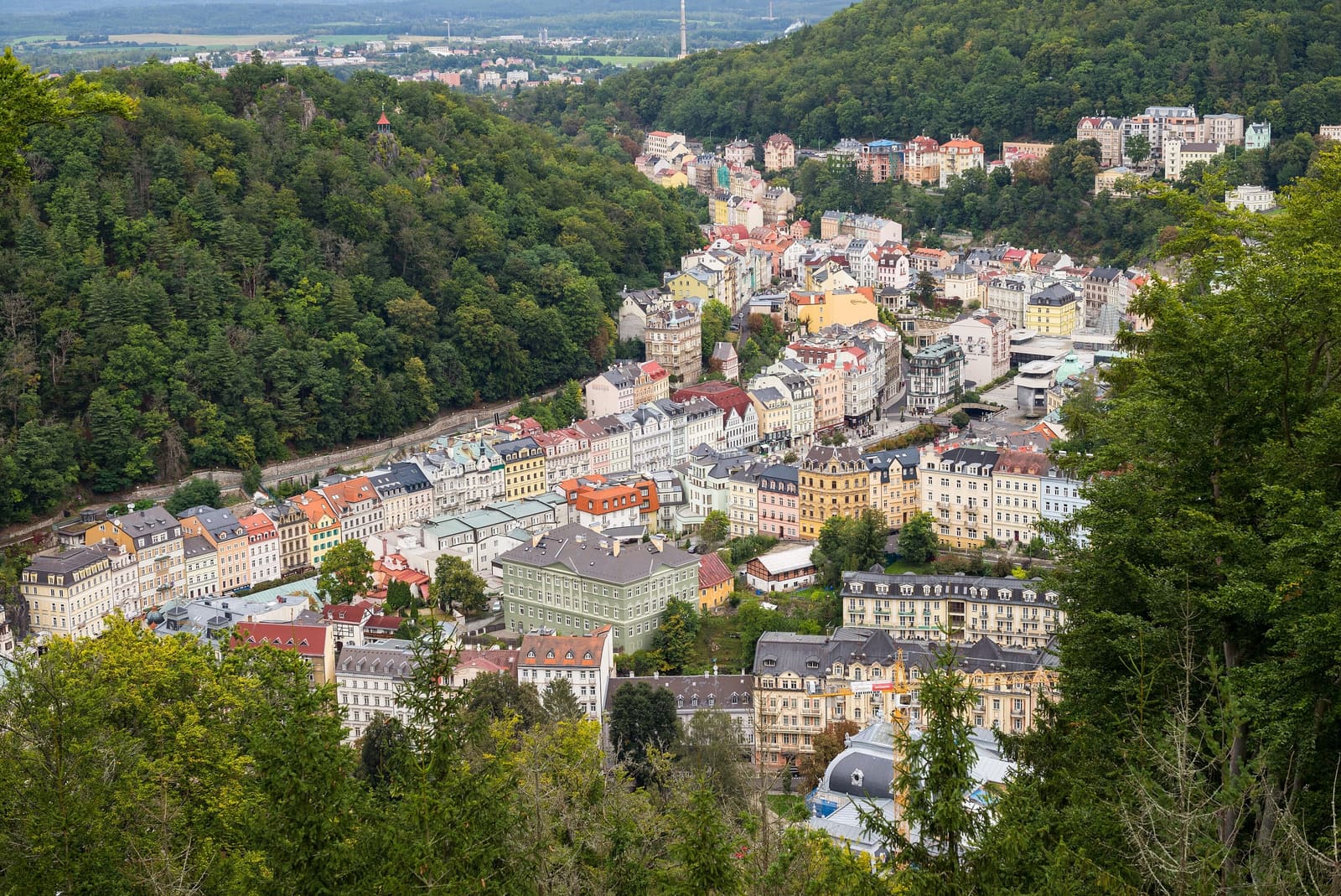 Kurviertel von Karlovy Vary zwischen bewaldeten Hügeln, von einem erhöhten Aussichtspunkt gesehen
