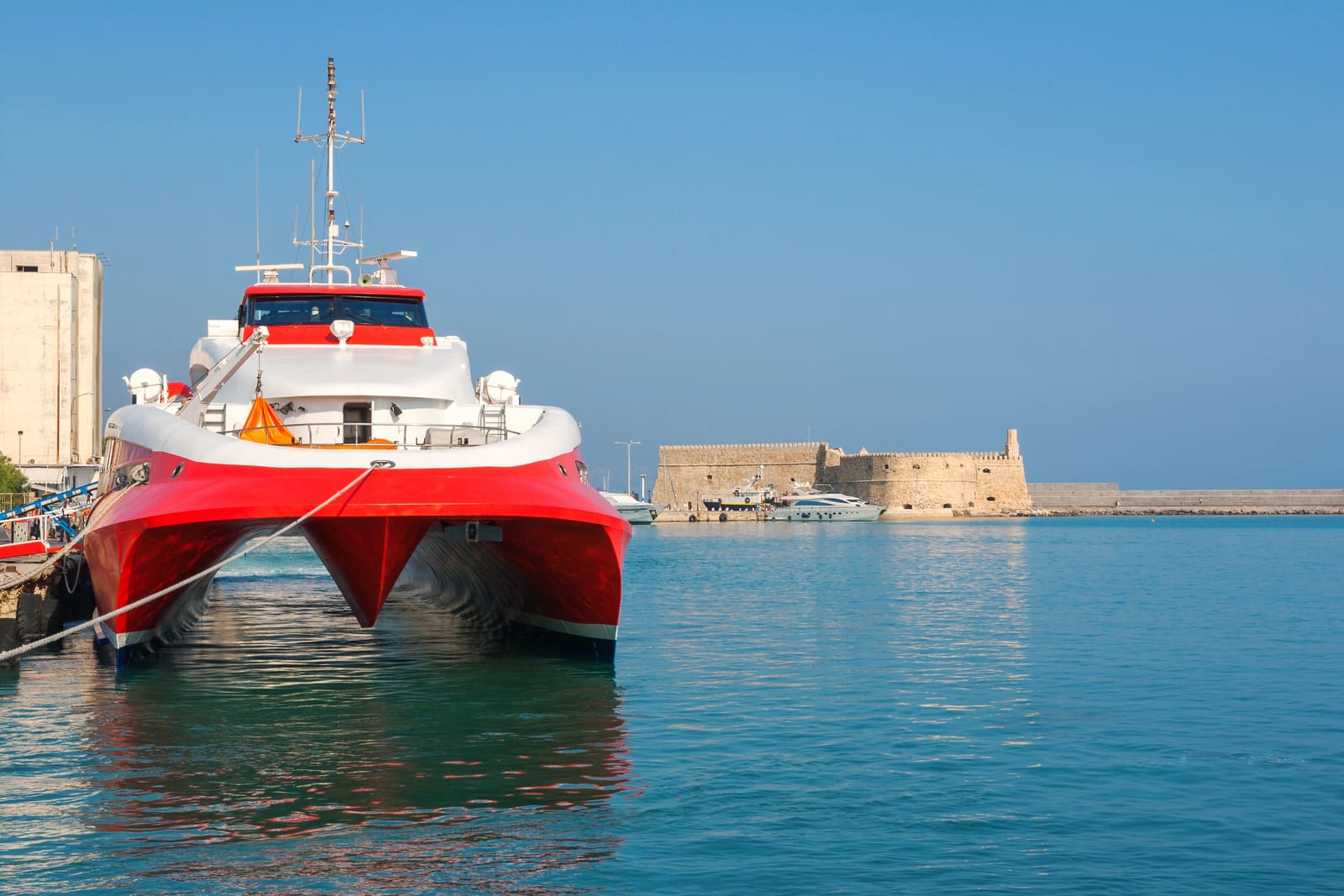 Ein Katamaran im Hafen von Heraklion, mit der Festung Koules im Hintergrund