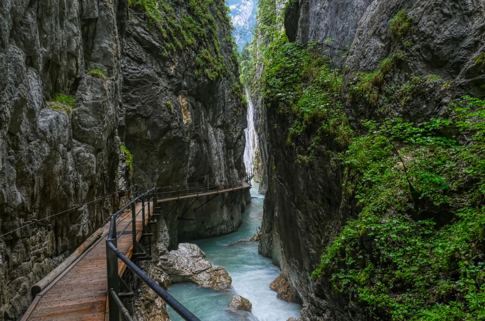 Hölzerner Klammsteig über dem türkisfarbenen Schmelzwasser der Leutaschklamm.