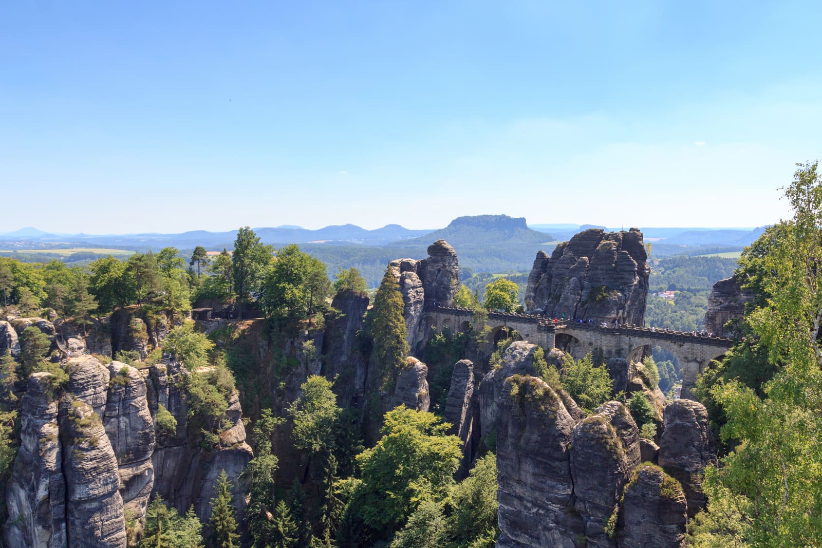Die Basteibrücke zwischen zerklüfteten Sandsteinfelsen und grünen Wäldern der Sächsischen Schweiz